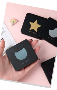 Close-up of black matte portable makeup mirror with gold star and moon pattern
