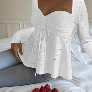 Close-up of white lace long-sleeve top with front drawstring and hollow-out detailing