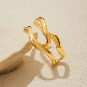Minimalist double-layer 18K gold wave open ring on a textured stone background