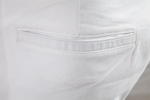 Gros plan de la poche arrière sur un short décontracté en coton blanc avec texture sergée