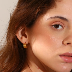 Close-up of triple-layered 18K gold-plated textured hoop earrings on a model