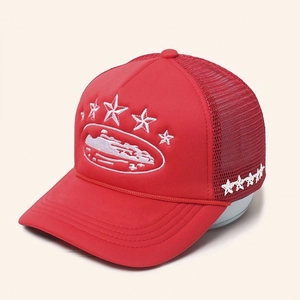 Detail view of red trucker hat featuring white five-star embroidery and mesh back panel
