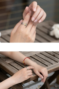 Detail of unique silver puzzle ring with gold accent worn by a model on a wooden table