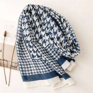 Detail of blue and white houndstooth scarf with fine weave texture and soft edges