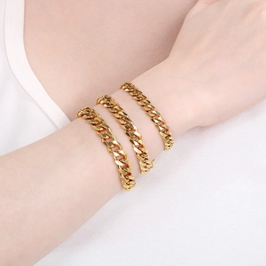 Close-up of stacked 18K gold plated Cuban chain bracelets in three different widths