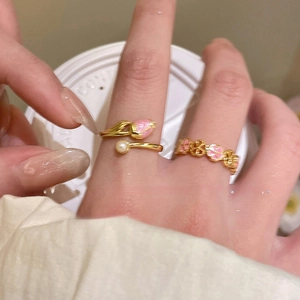 Detailed close-up of 18k gold plated open rings with tulip and cherry blossom enamel