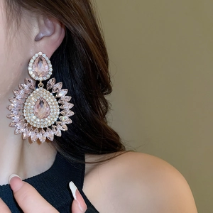 Close-up of sparkling champagne water drop flower earrings worn by a model