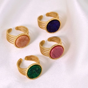 Detailed view of four adjustable gold-plated rings with colorful natural stone inlays