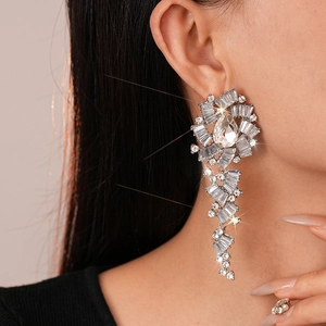 Close-up of sparkling flower teardrop tassel earrings with rhinestones on a model