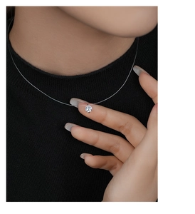Detailed close-up of a sparkling moissanite pendant on a transparent fishing line necklace