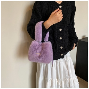 Detail of a purple plush bucket bag with a golden metal tag and soft furry handle
