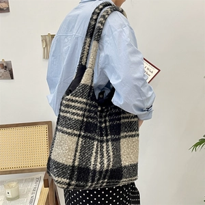 Detail shot of a plush striped tote bag featuring black and white checkerboard pattern