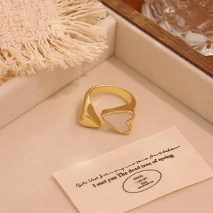 Detail of 18K gold plated ring featuring double heart design with white shell inlay