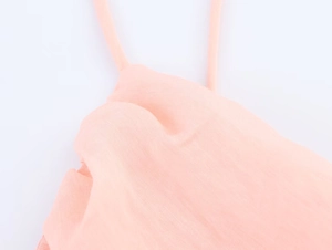Detail view of thin pink spaghetti straps and neckline on textured summer midi dress