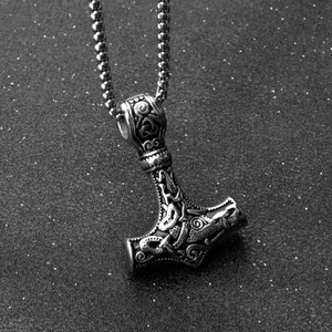 Macro shot of Mjolnir pendant with Celtic knots on metal bead chain for men