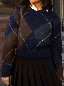 Gros plan sur un pull en maille à carreaux avec chemise blanche et jupe plissée noire