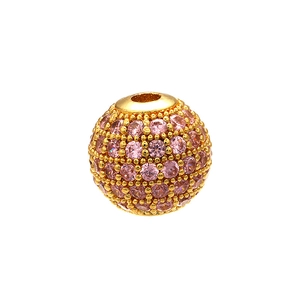 Macro shot of a gold-plated bead with micro-pave pink crystals for DIY jewelry