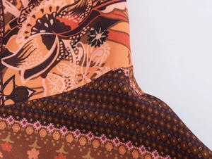 Gros plan du tissu de la robe longue ethnique avec motifs floraux et géométriques