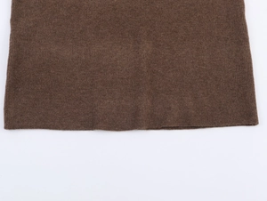 Close-up of dark brown knit fabric texture showing vertical ribbing and dense wool fibers