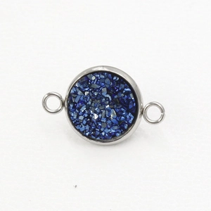 Detailopname van een ronde roestvrijstalen connector met blauwe glinsterende hars