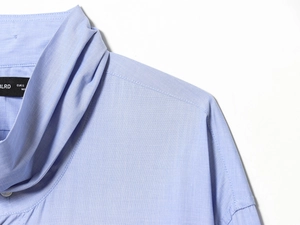 Close-up of a light blue shirt collar with high-quality stitching and EUR S size tag