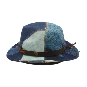 Close-up of vintage denim patchwork fedora hat with brown leather band and metal badge