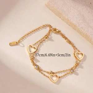 Detail view of double-layer stainless steel bracelet with heart charms and white zircons