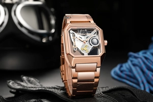 Macro shot of rose gold skeleton watch on biker gear showing internal gears and metal texture