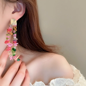 Elegant gold earrings featuring colorful stone tassels on a model for a stylish look