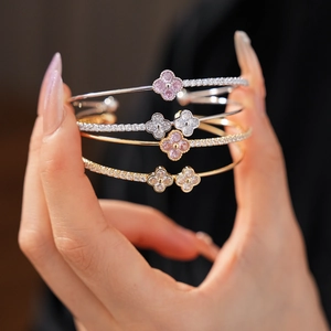 Detail of clover zircon bracelets in gold and silver finish worn by a model
