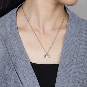Détail du collier en or rose avec pendentif double bonheur porté au cou