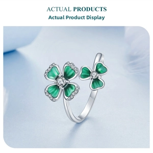 Detailed macro view of silver clover ring with green enamel and zircon inlay