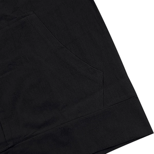 Detailed close-up of double-stitched pocket seams and hem on a black linen hooded shirt