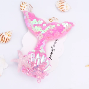 Detail of pink sequin mermaid tail hair clip with shell and starfish resin charms