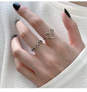 Detail of vintage s925 silver hollow heart rings worn on finger with antique finish