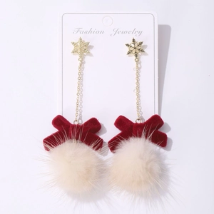 Detailed shot of Christmas tree earrings with red velvet bows and white plush pom-poms