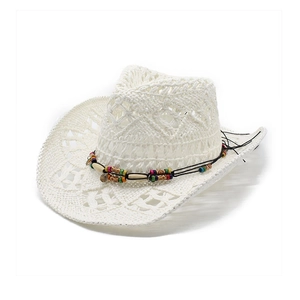 Dettaglio di cappello da cowboy bianco intrecciato con perline e trama floreale
