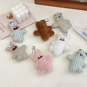 Close-up of cute plush bear and bunny keychains with colorful patterns and metal chains