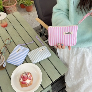 Three striped fabric cosmetic bags in pink, blue, and green colors with wrist straps