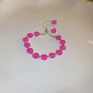 Ethnic style rose red beaded bracelet with golden accents and adjustable drawstring cord