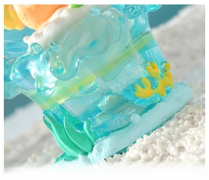 Detailed macro view showing the blue resin ocean base with green seaweed and yellow coral