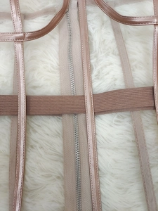 Detail eines sexy zweiteiligen Sets in Roségold mit Mesh-Stoff und Metallreißverschluss