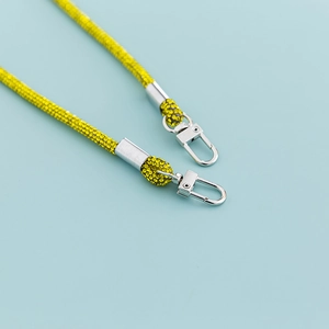 Detail of yellow rhinestone crossbody strap with silver metal swivel spring clasps