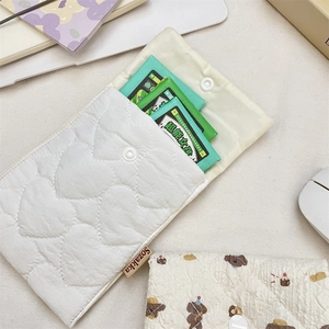 Quilted heart pattern sanitary napkin storage bag with button closure and brand label