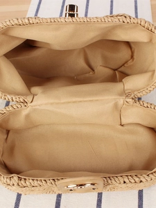 Internal view of a woven straw handbag featuring a durable lining and gold metal clasp