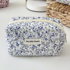 Detailed close-up of lavender floral quilted cotton cosmetic bag with zipper and woven label