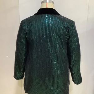 Detail view of the back of a dark green sequined blazer with elegant velvet lapel