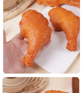 Macro di un modello realistico di coscia di pollo fritto da 15cm tenuto in mano