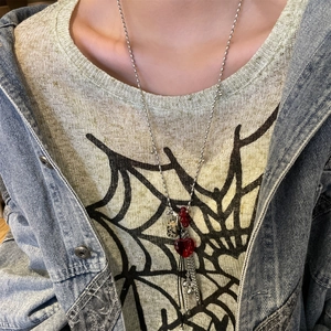 Close-up of heart crystal pendant with layered tassels on a beaded chain necklace