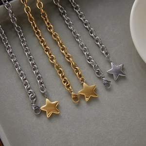 Detailed macro of stainless steel star necklaces in gold and silver on velvet